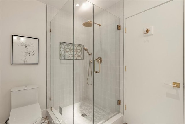 bathroom with an enclosed shower and toilet