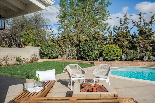 view of swimming pool with a yard, a patio area, and an outdoor fire pit