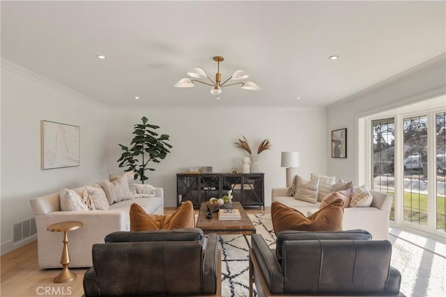 living room featuring an inviting chandelier, crown molding, and light wood-type flooring