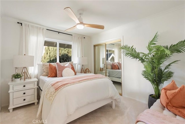 bedroom featuring crown molding, light colored carpet, and ceiling fan