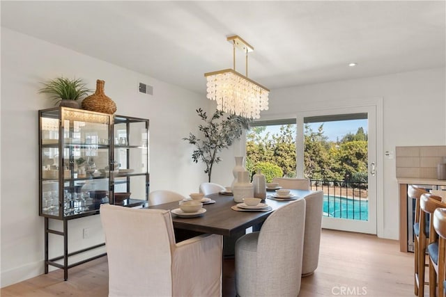 dining area featuring an inviting chandelier and light hardwood / wood-style flooring