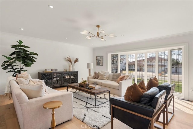 living room featuring a notable chandelier, light hardwood / wood-style flooring, and ornamental molding