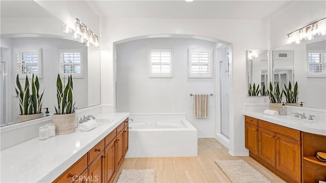 bathroom with tile patterned floors, vanity, and plus walk in shower