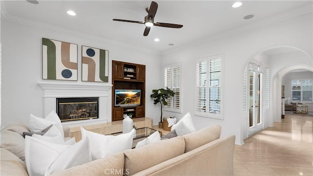 tiled living room featuring ceiling fan and ornamental molding