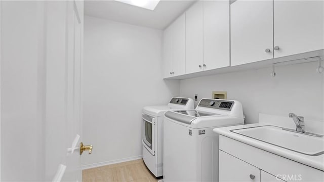 laundry room featuring sink, washer and clothes dryer, and cabinets