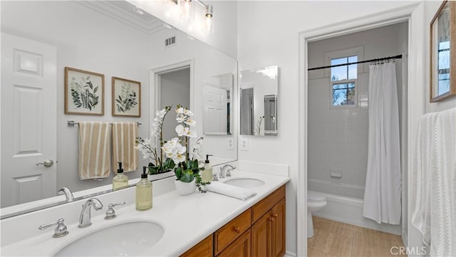 full bathroom featuring toilet, vanity, and shower / bathtub combination with curtain