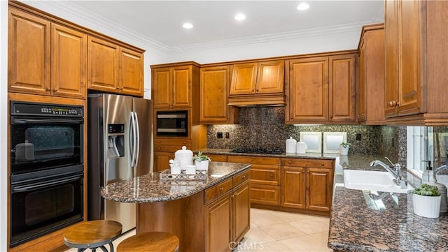 kitchen featuring a breakfast bar, crown molding, dark stone counters, decorative backsplash, and black appliances