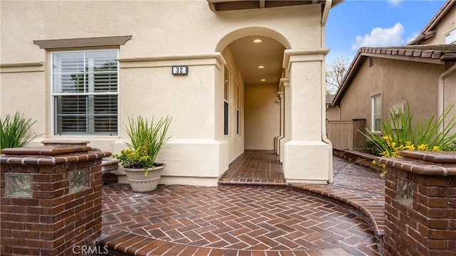 view of exterior entry with a patio area