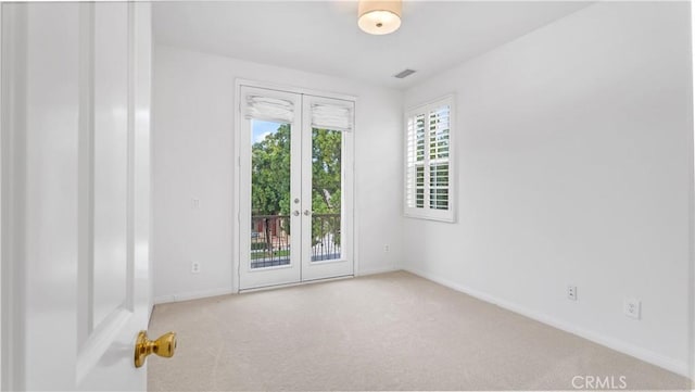 unfurnished room with light carpet and french doors