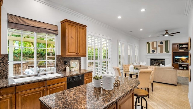 kitchen with dark stone countertops, sink, a breakfast bar area, and black dishwasher