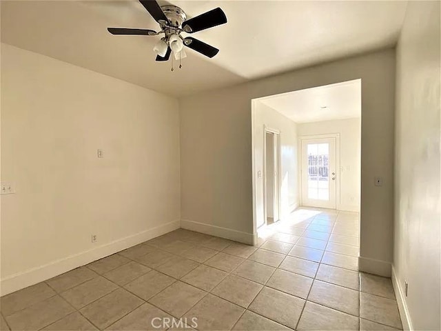 tiled spare room featuring ceiling fan