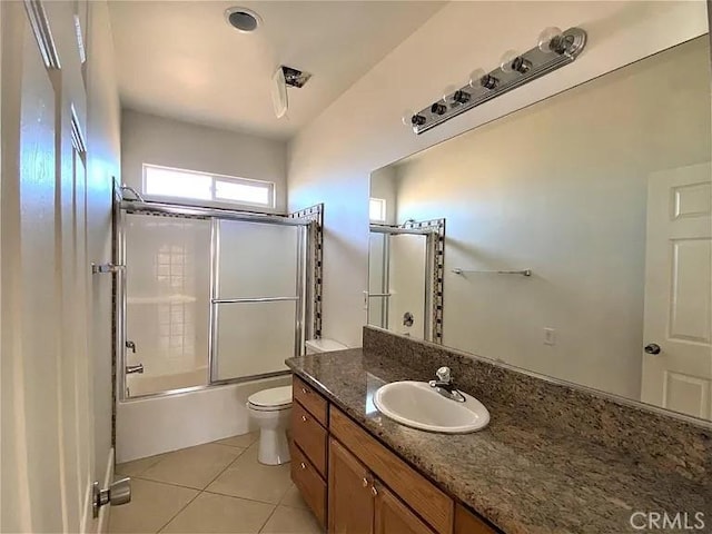 full bathroom featuring tile patterned flooring, vanity, bath / shower combo with glass door, and toilet