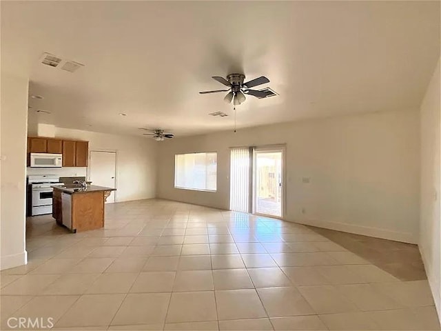 unfurnished living room with ceiling fan and light tile patterned floors