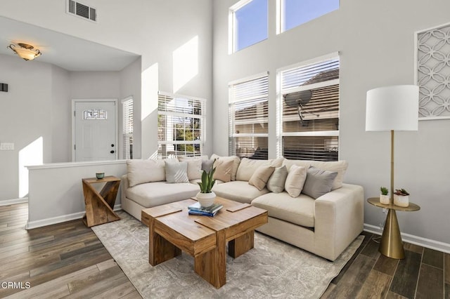 living room featuring dark hardwood / wood-style floors and a towering ceiling