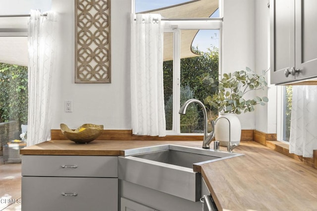 kitchen featuring sink, a wealth of natural light, wood counters, and gray cabinetry