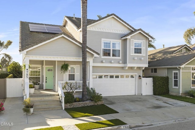 view of front of property with a garage, solar panels, and covered porch