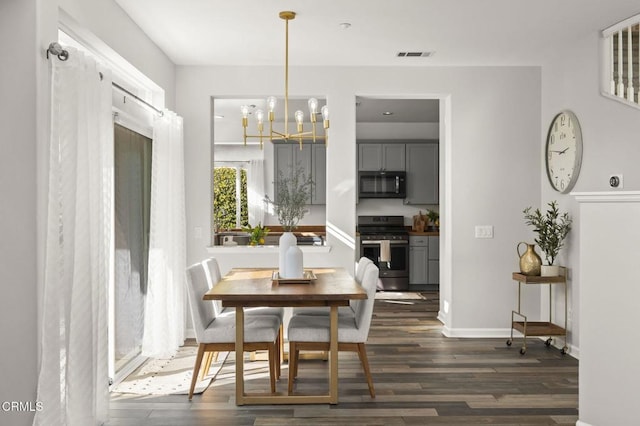 dining space featuring dark hardwood / wood-style flooring and a notable chandelier