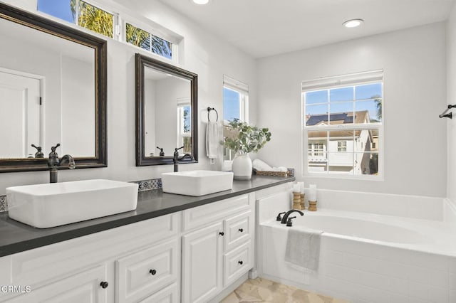 bathroom featuring vanity and a relaxing tiled tub