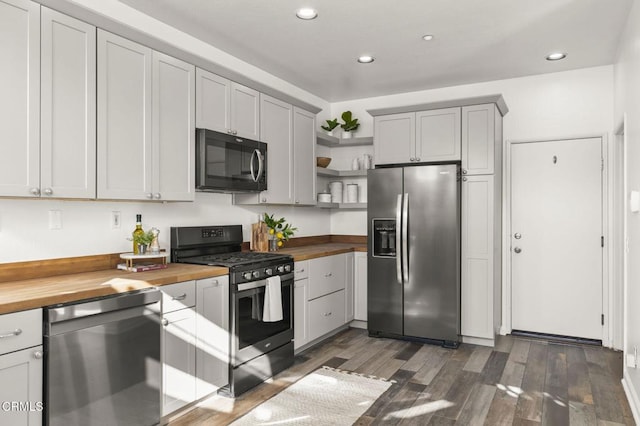 kitchen featuring dark hardwood / wood-style floors, gray cabinets, wooden counters, and appliances with stainless steel finishes