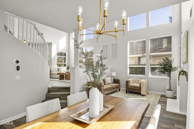 dining space with an inviting chandelier, dark hardwood / wood-style floors, and a high ceiling