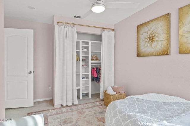 carpeted bedroom featuring ceiling fan and a closet