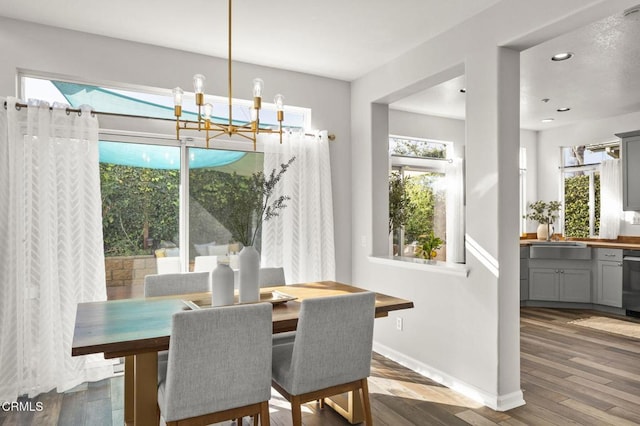 dining area with dark hardwood / wood-style floors, sink, and a chandelier