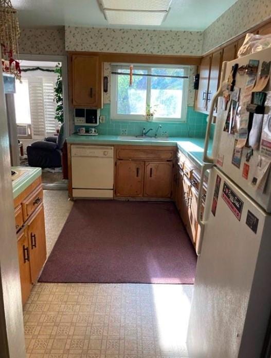 kitchen featuring sink, backsplash, and white appliances