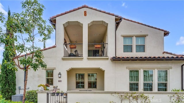 back of house featuring central AC unit and a balcony