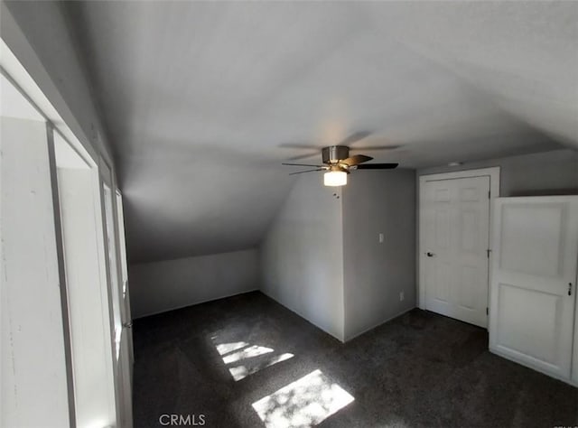 bonus room featuring dark carpet and vaulted ceiling