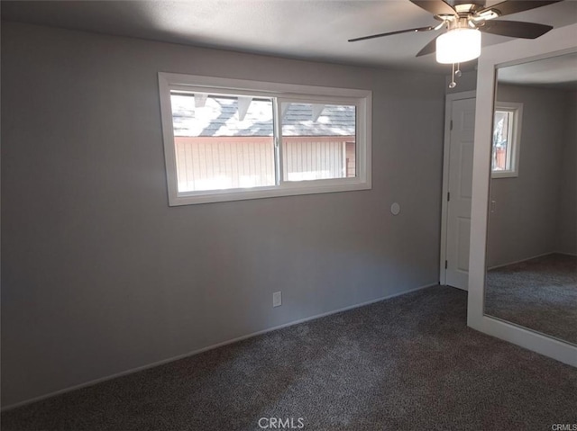 carpeted spare room with ceiling fan