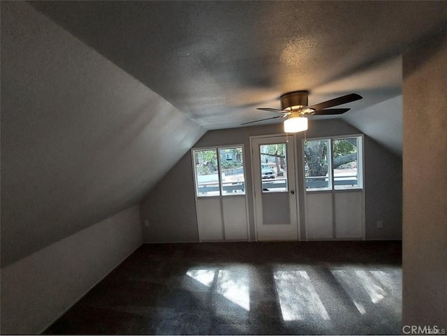 bonus room featuring ceiling fan, lofted ceiling, carpet, and a textured ceiling