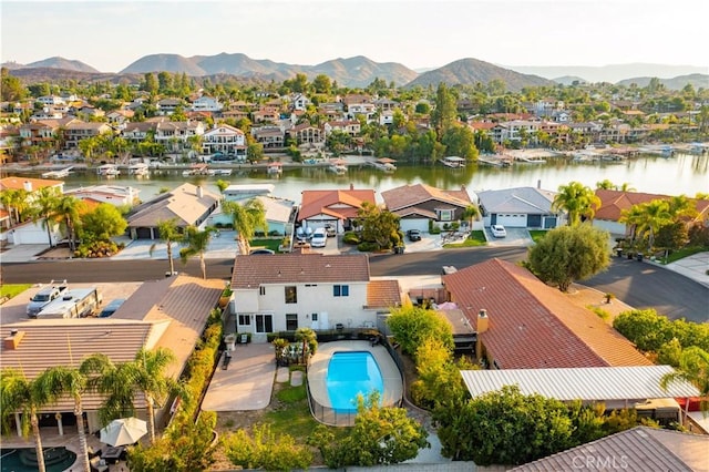 drone / aerial view featuring a water and mountain view and a residential view