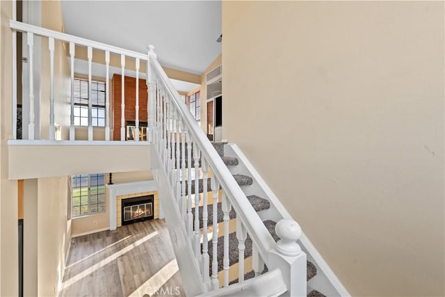 30340 Channel Way Dr, Canyon Lake, CA 92587 - stairway featuring baseboards, a towering ceiling, wood finished floors, and a wealth of natural light