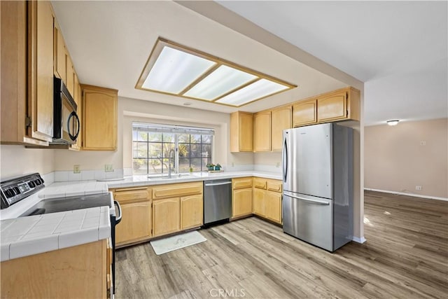 30340 Channel Way Dr, Canyon Lake, CA 92587 - kitchen featuring light brown cabinetry, appliances with stainless steel finishes, a sink, light wood-style floors, and tile counters