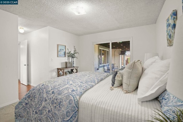 bedroom featuring access to outside and a textured ceiling