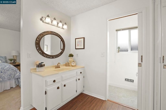 bathroom with vanity, hardwood / wood-style flooring, and a textured ceiling