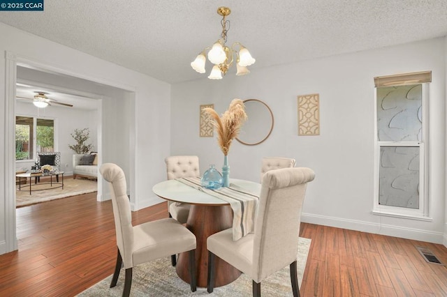 dining space with dark hardwood / wood-style flooring, a chandelier, and a textured ceiling