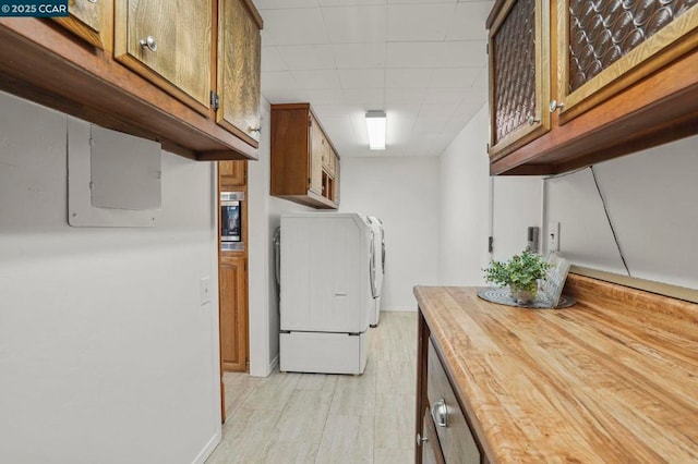 laundry room with cabinets, independent washer and dryer, and light wood-type flooring