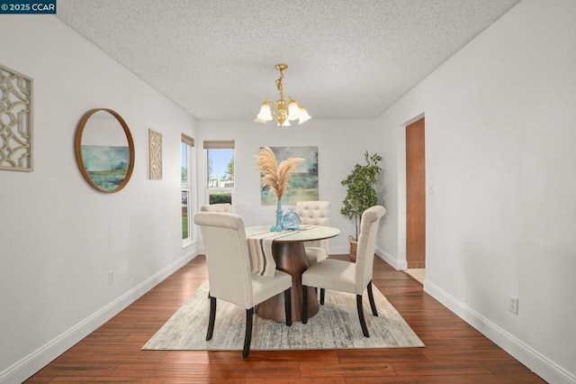 dining space featuring dark hardwood / wood-style flooring, a chandelier, and a textured ceiling