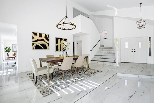 dining area featuring an inviting chandelier and high vaulted ceiling