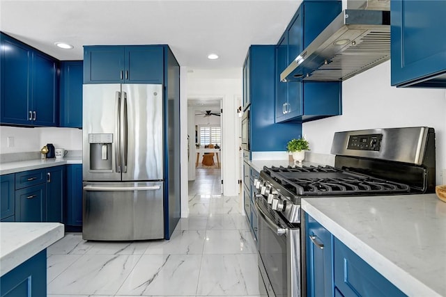 kitchen featuring blue cabinets, wall chimney range hood, and appliances with stainless steel finishes