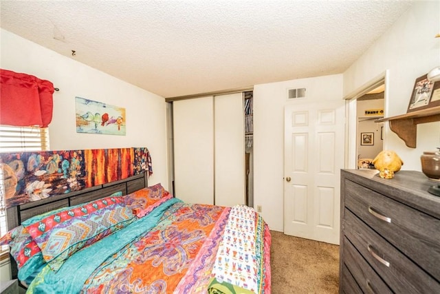 carpeted bedroom featuring a closet and a textured ceiling