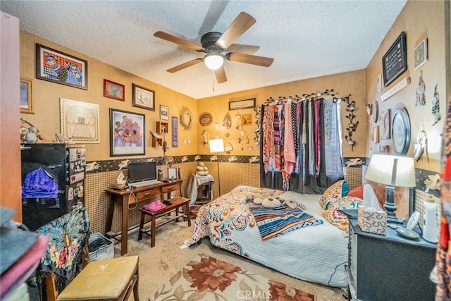 bedroom with ceiling fan, carpet flooring, and a textured ceiling