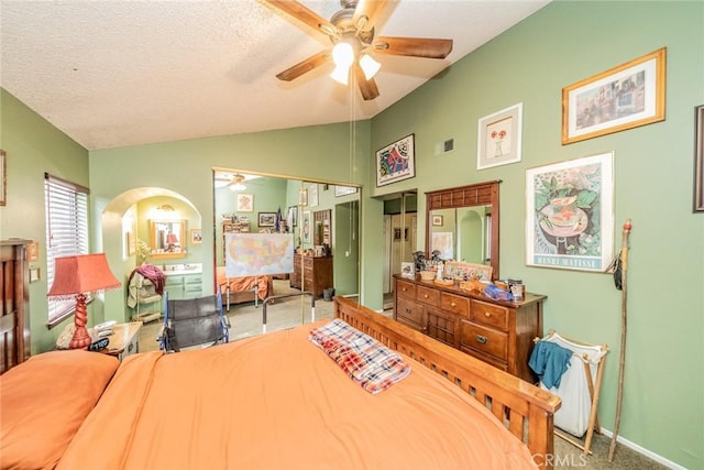 bedroom with ceiling fan, light colored carpet, lofted ceiling, and a textured ceiling