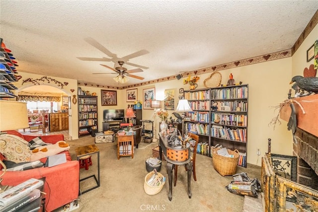 office space with ceiling fan, a fireplace, carpet floors, and a textured ceiling