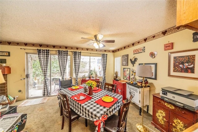 carpeted dining space with a textured ceiling and ceiling fan