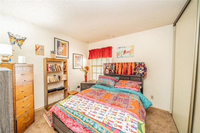 bedroom featuring light carpet and a textured ceiling