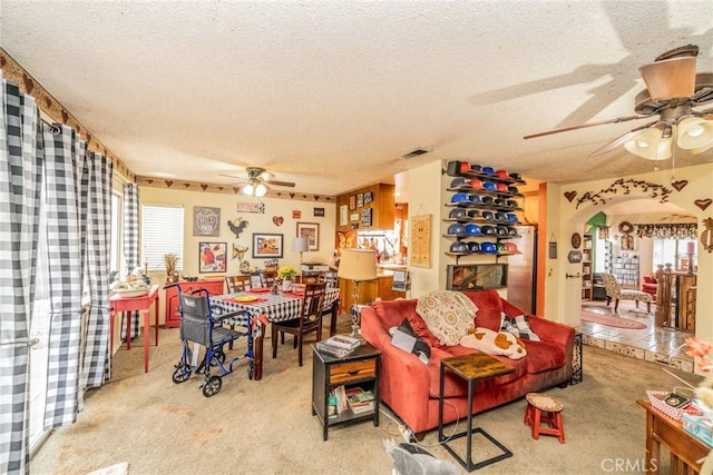 carpeted living room with ceiling fan and a textured ceiling