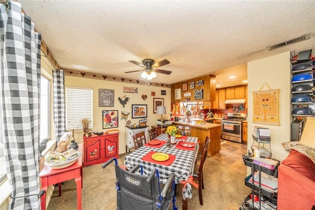 carpeted dining area with ceiling fan and a textured ceiling