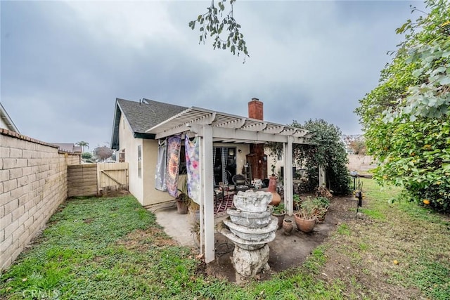 rear view of property with a pergola and a lawn